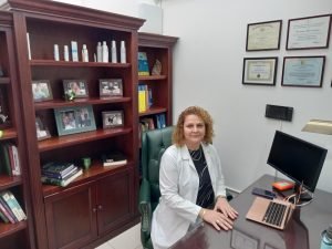 Woman behind desk.